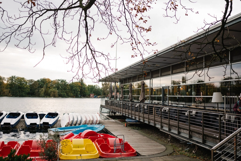 Seerestaurant mit Terrasse und bunten Tretbooten.