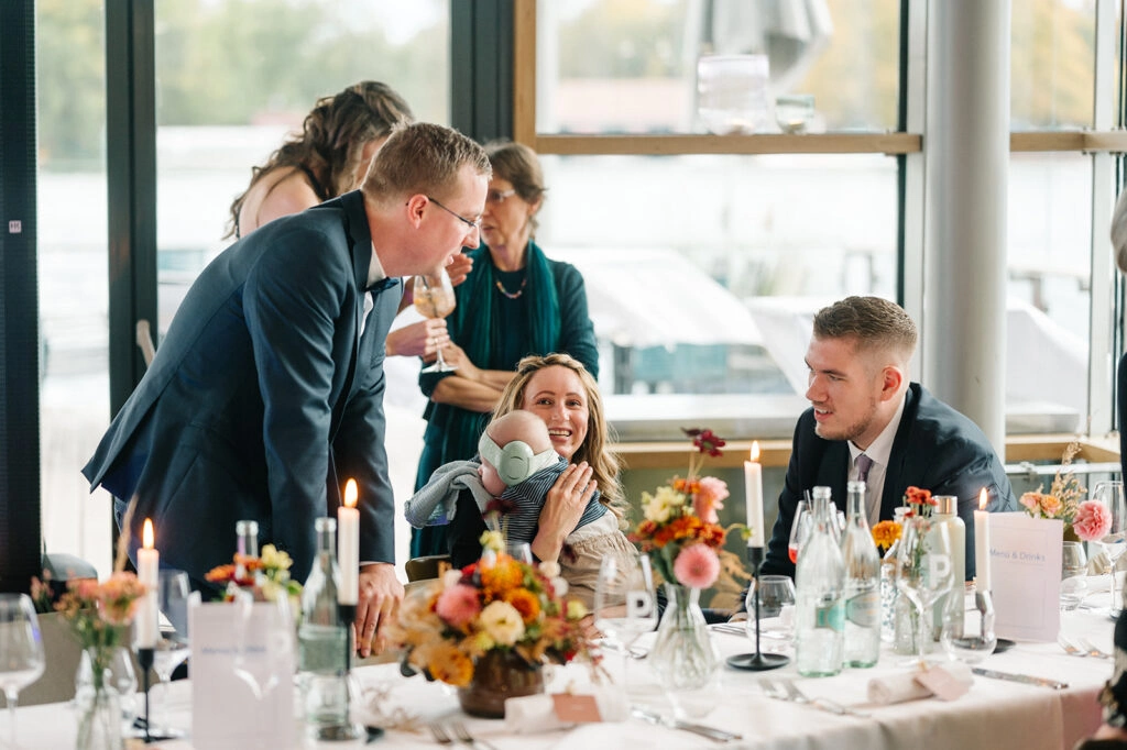 Gäste unterhalten sich an der Hochzeitstafel.