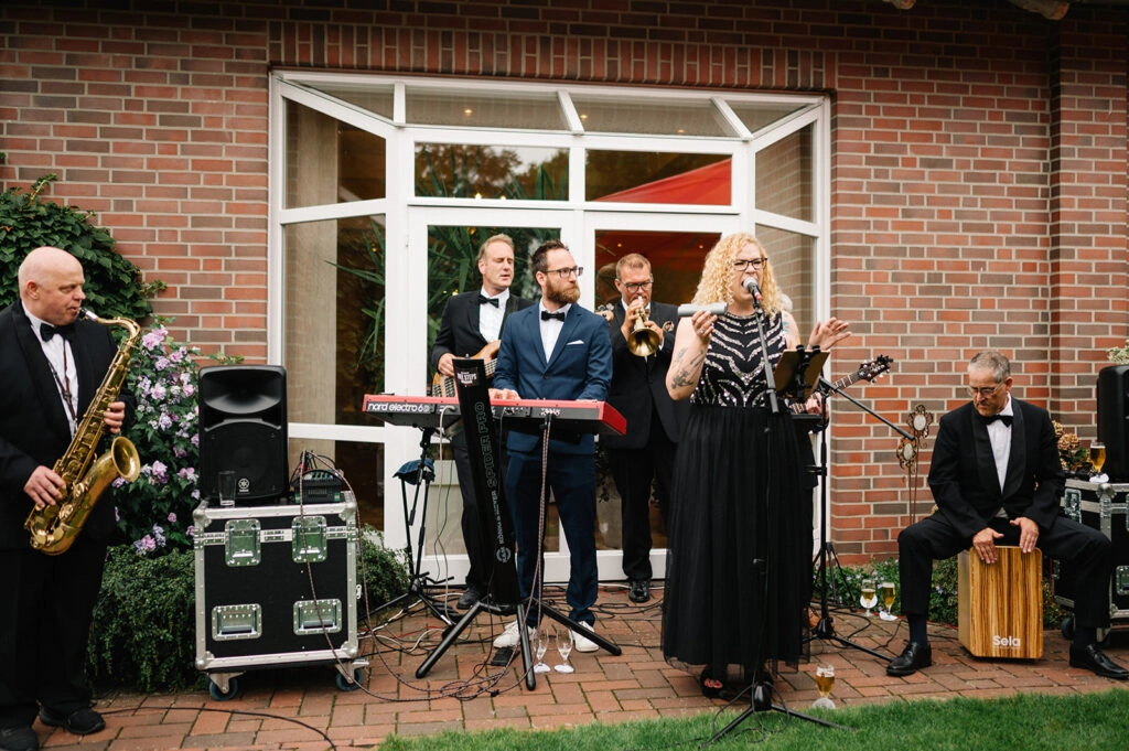Musikgruppe spielt vor einer geöffneten Terrassentür.
