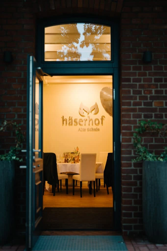 Beleuchteter Eingang einer Hochzeitslocation am Abend.