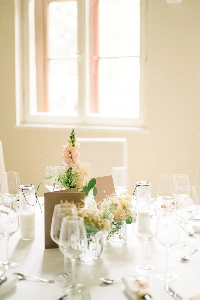Blumenschmuck auf einer hell eingedeckten Festtafel.