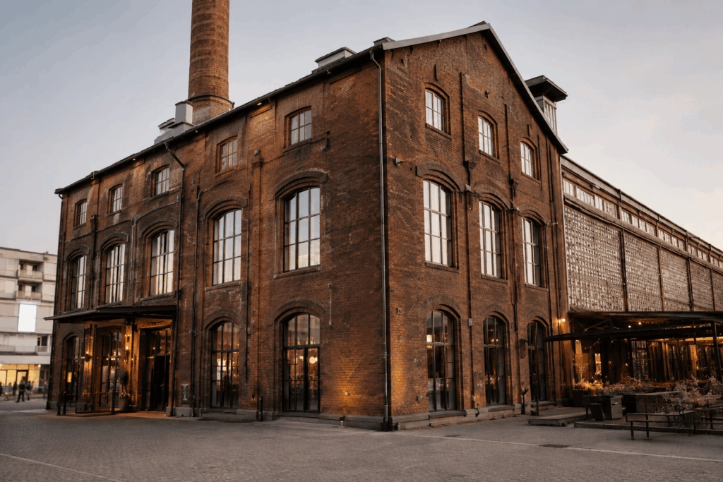Backsteingebäude der Seifenfabrik mit hohen Fenstern und Schornstein am Abend.