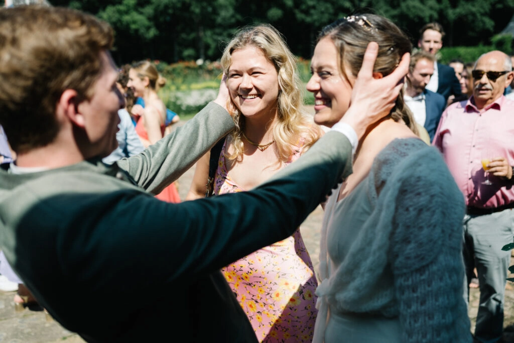 Gäste begrüßen einander beim Hochzeitsempfang.