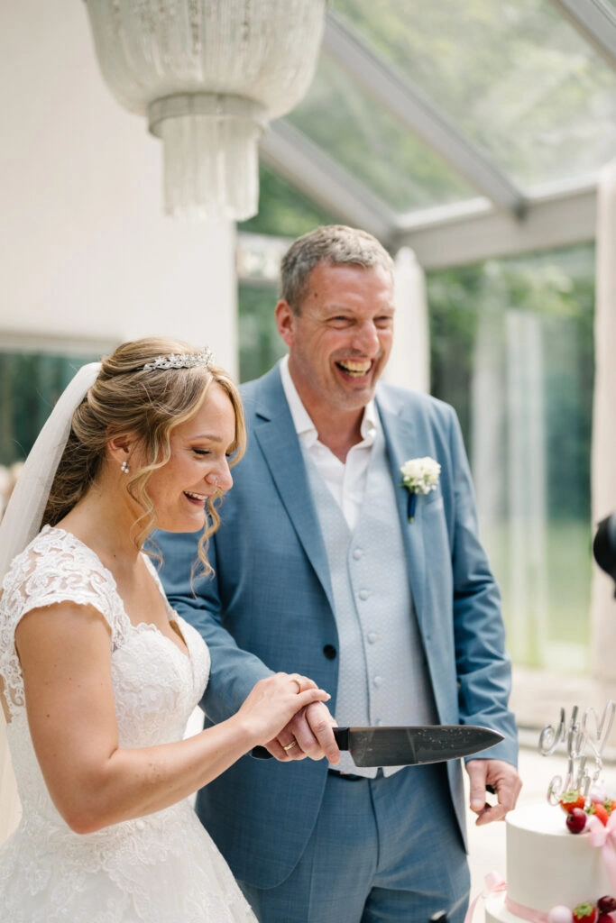 Brautpaar bereitet das Anschneiden der Hochzeitstorte vor.