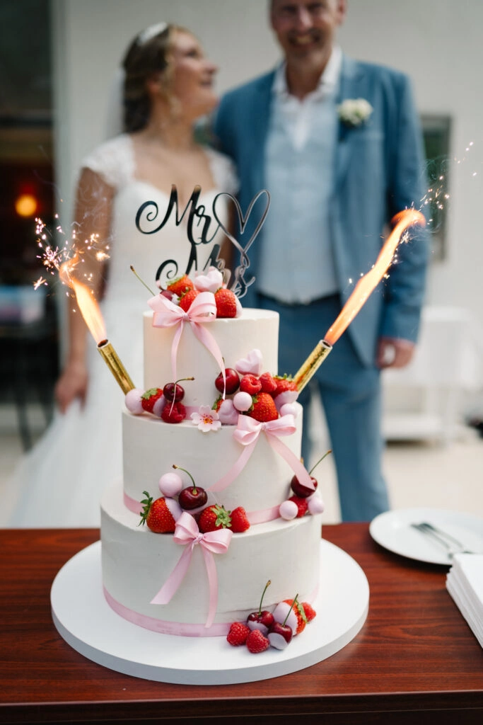 Mehrstöckige Beerentorte mit brennenden Wunderkerzen.