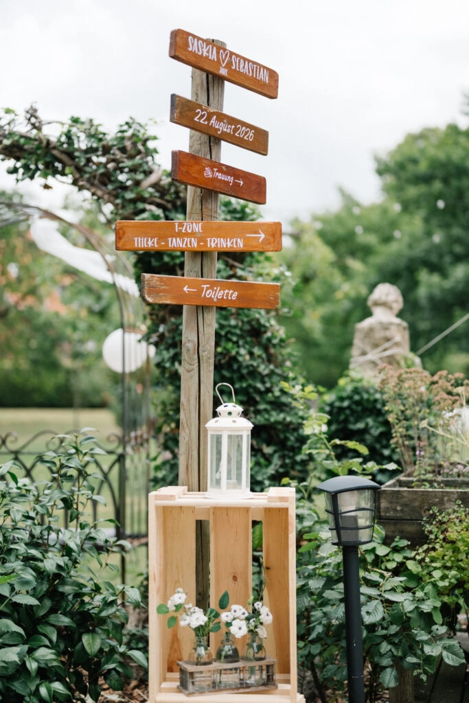 Wegweiser aus Holz im Hochzeitsgarten.