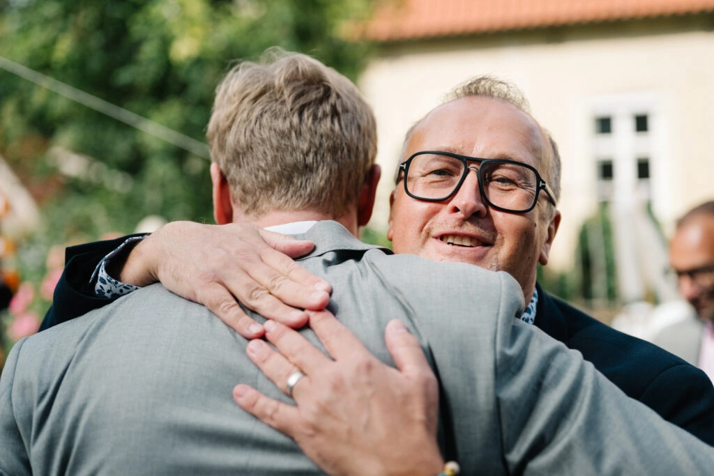 Gast umarmt den Bräutigam bei den Glückwünschen.