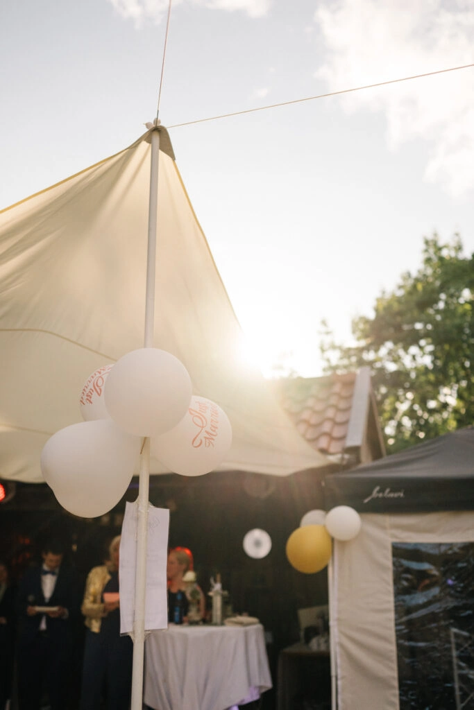 Weiße Luftballons am Festzelt im Gegenlicht.