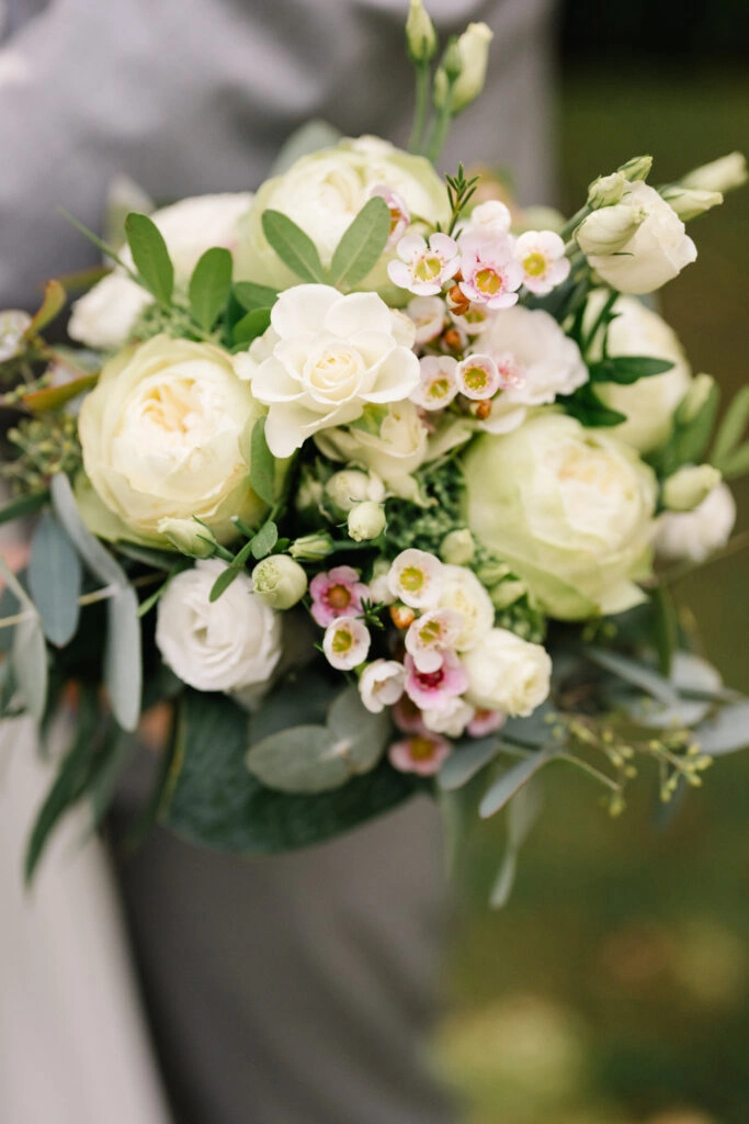 Brautstrauß mit hellen Rosen und kleinen Blüten.