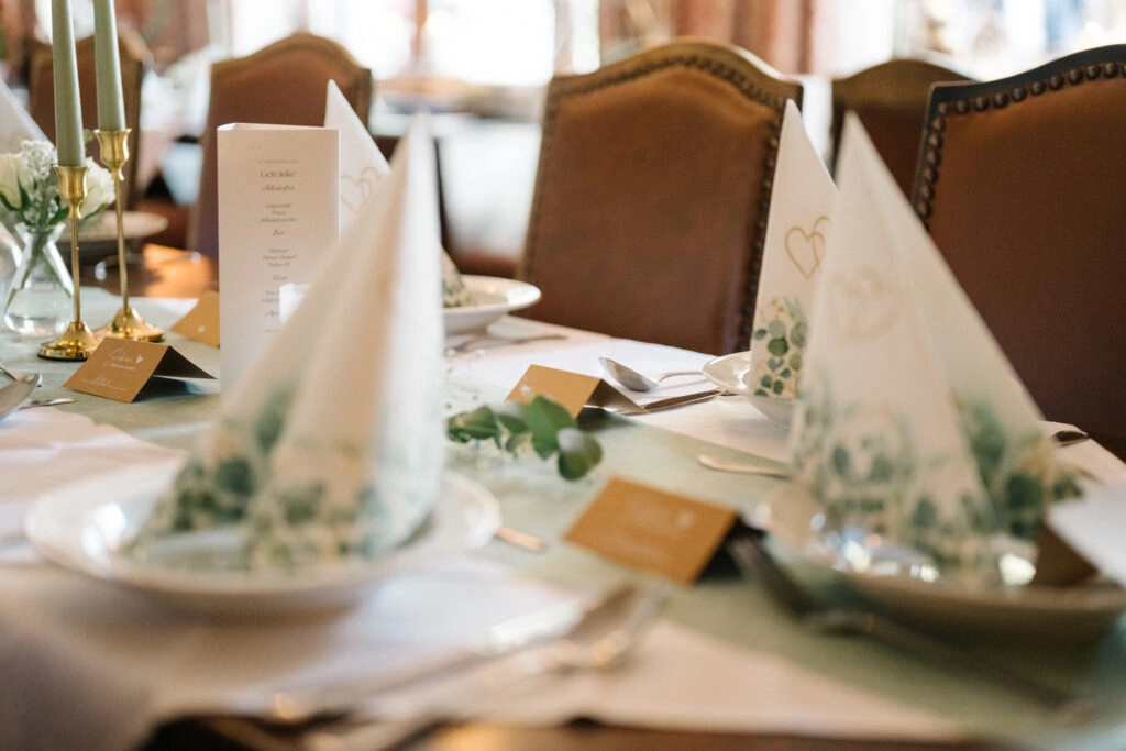 Festlich gedeckte Hochzeitstafel mit Kerzen und Servietten.