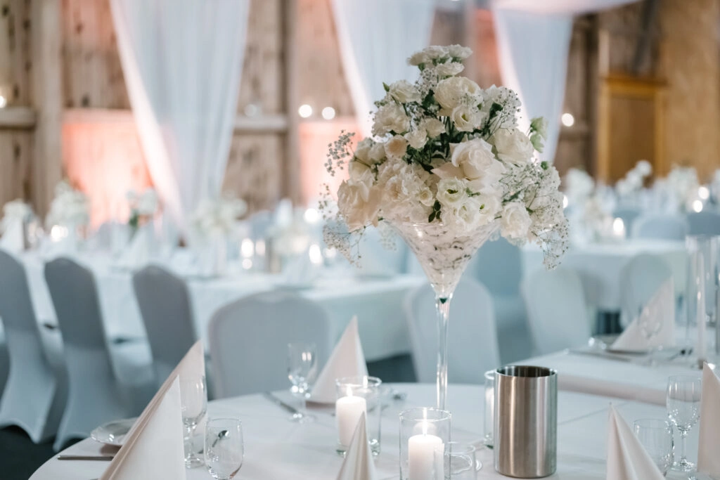 Festlich gedeckter Hochzeitstisch mit weißen Blumen und Kerzen.