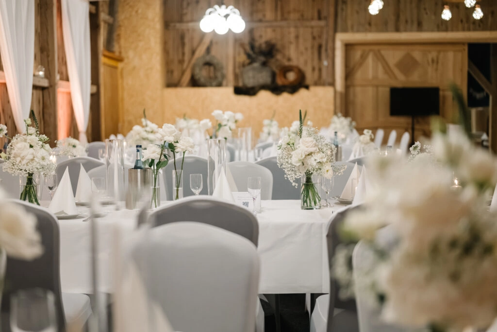 Hochzeitssaal der Gaststätte Bramlage mit weiß eingedeckten Tischen.